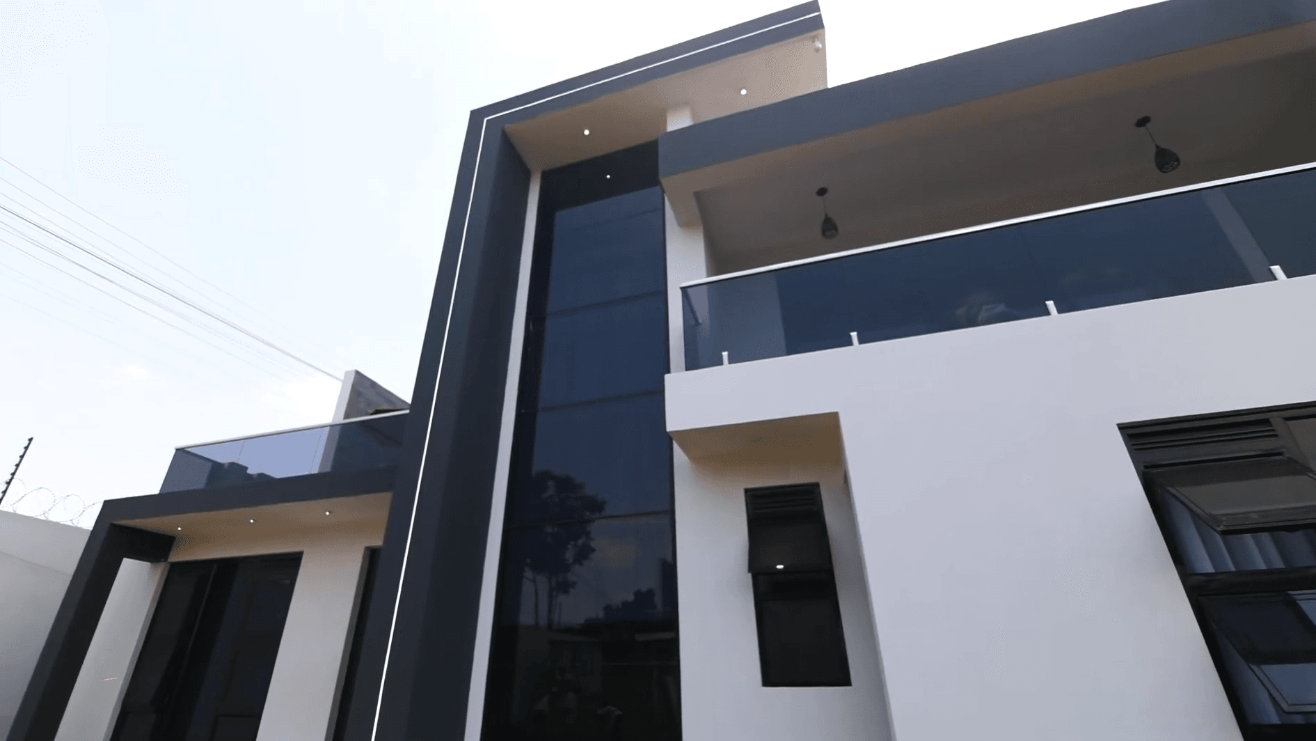 Contemporary villa exterior featuring charcoal cladding and glass balustrades