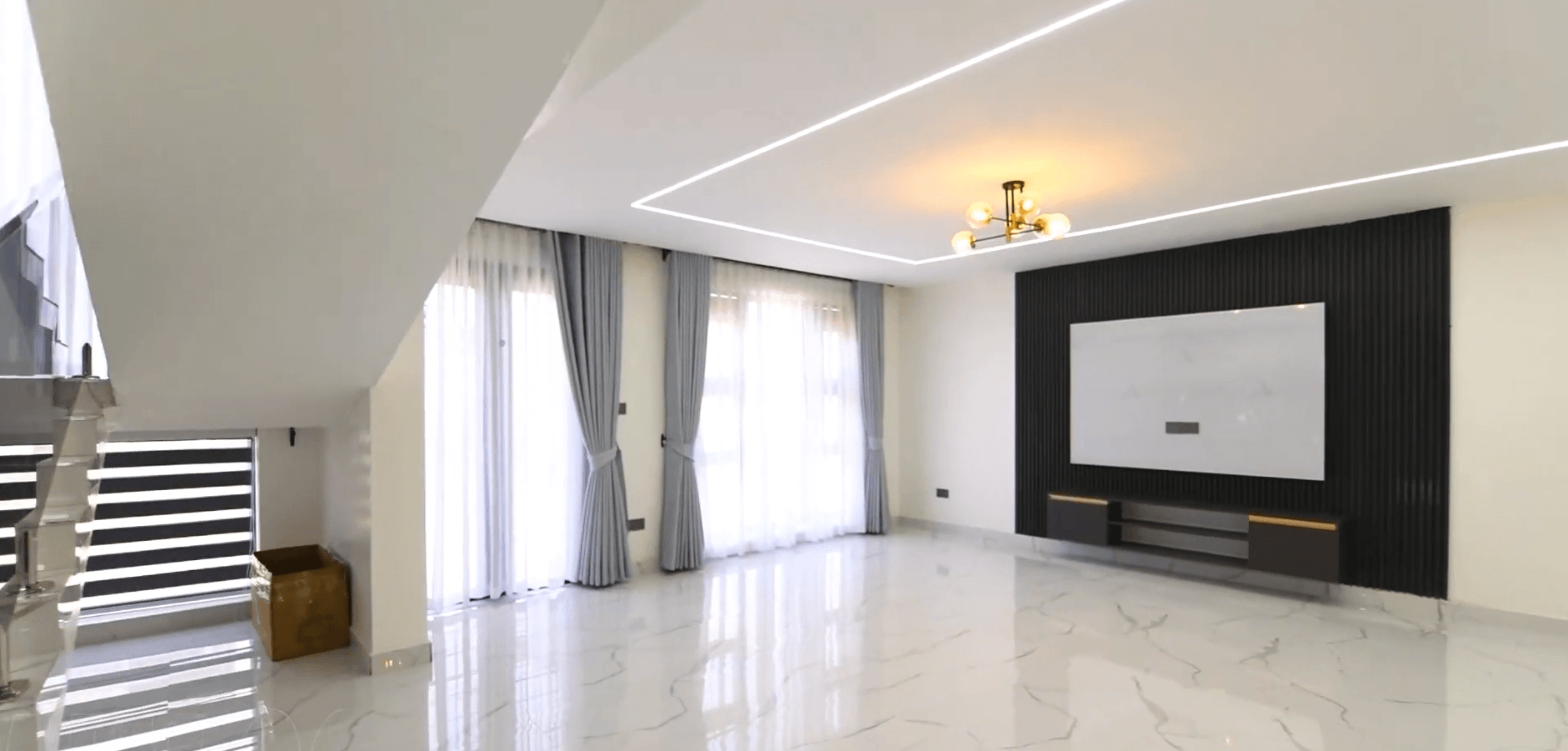 Open-plan living room with marble floors and designer ceiling